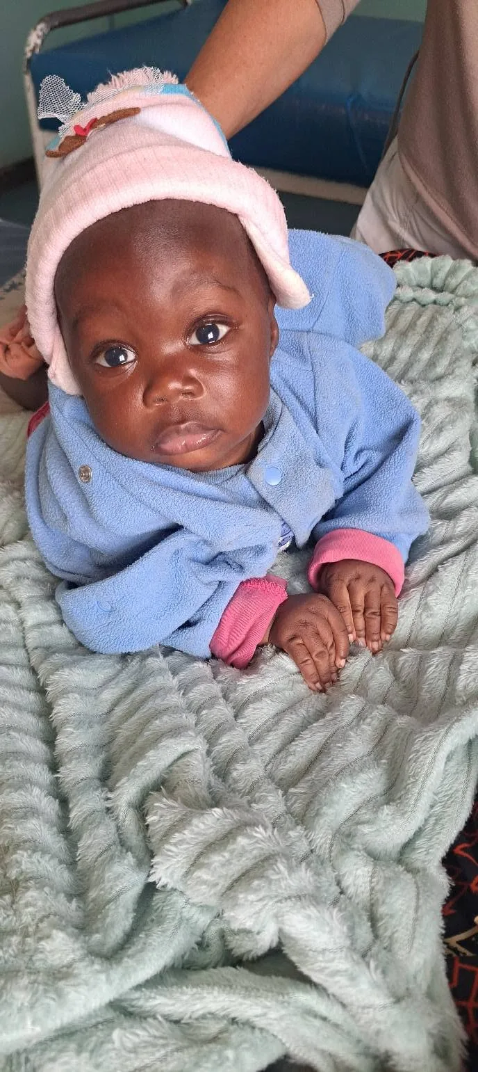 An infant wrapped warmly during a care visit